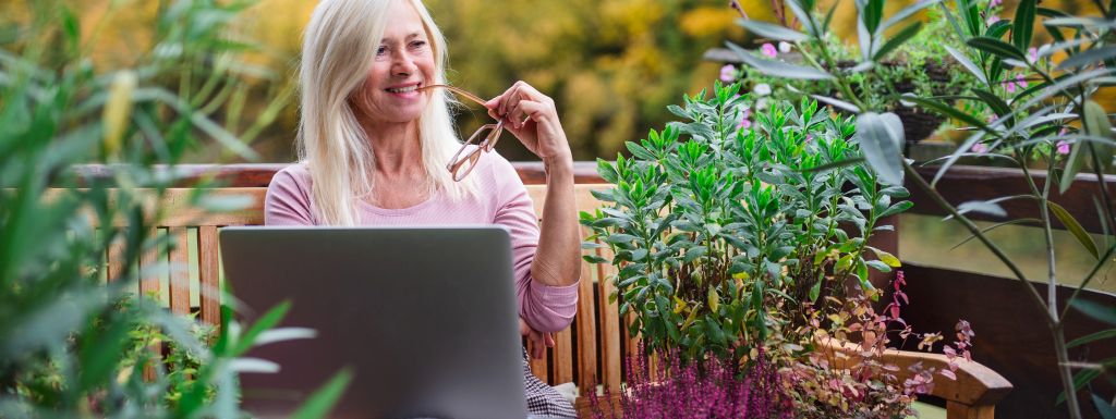 kobieta pracująca na laptopie w ogrodzie